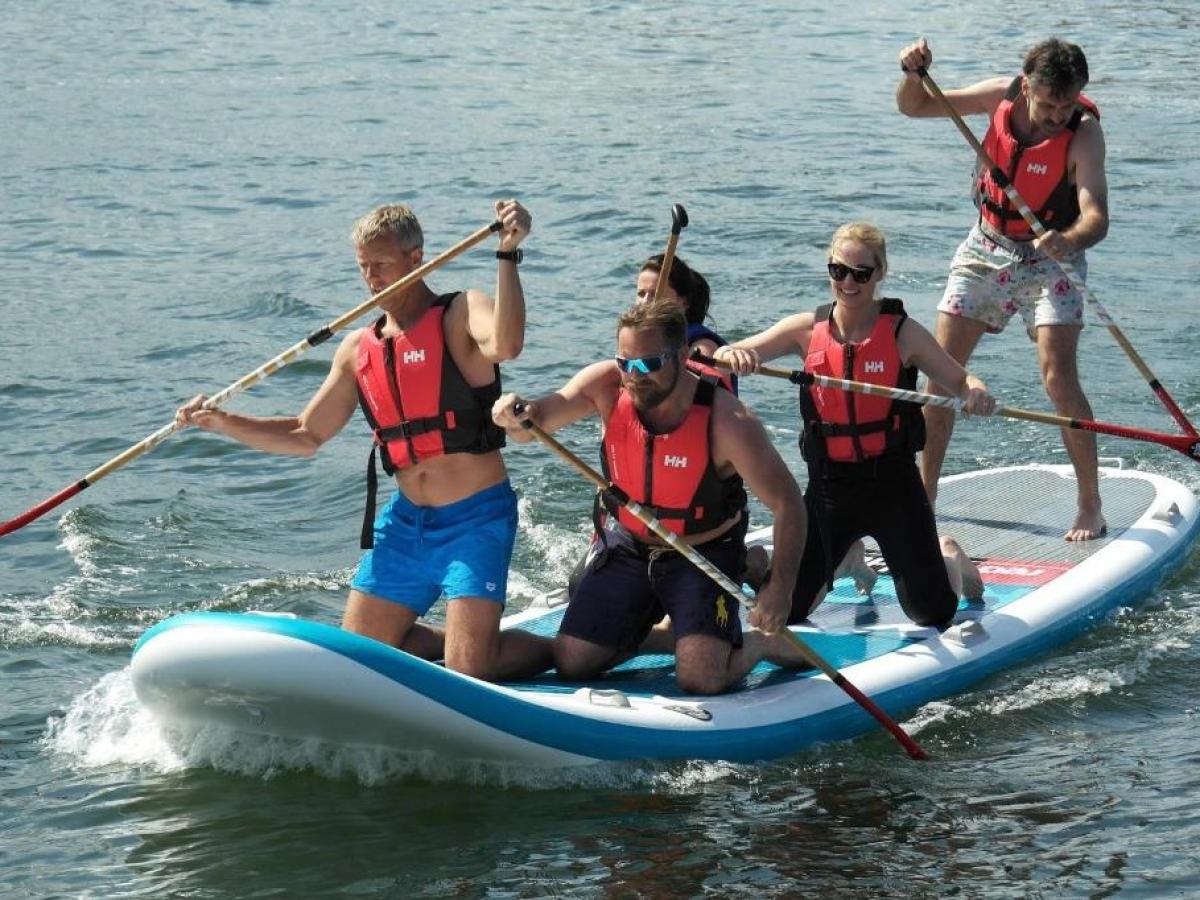 a group of people riding on the back of a boat in the water