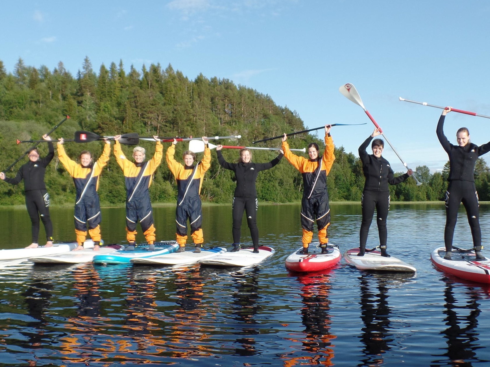 a group of people riding on the back of a boat in the water