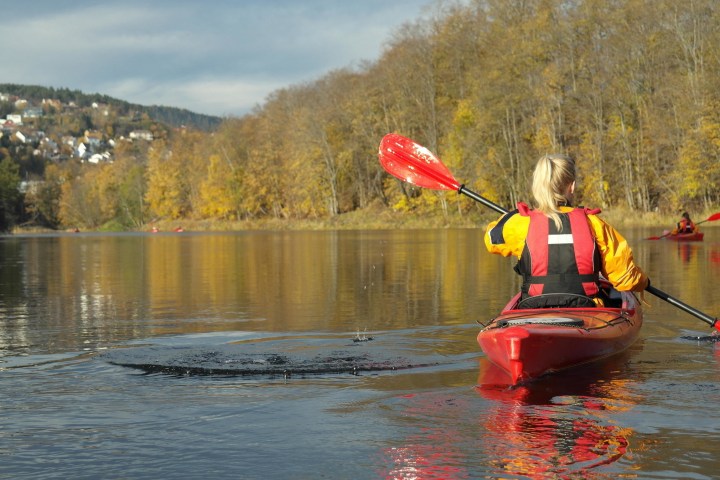 a man riding on the back of a boat in the water