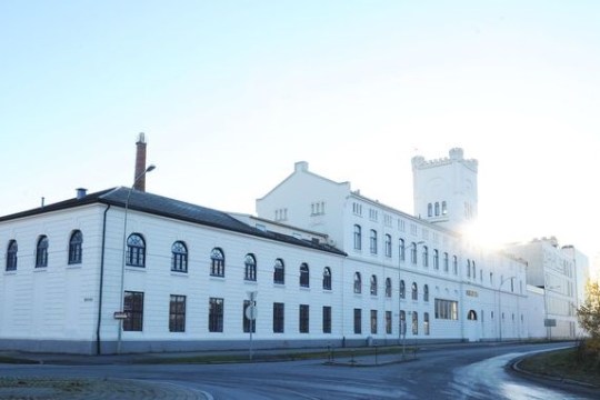 a large building with a clock on the side of a road
