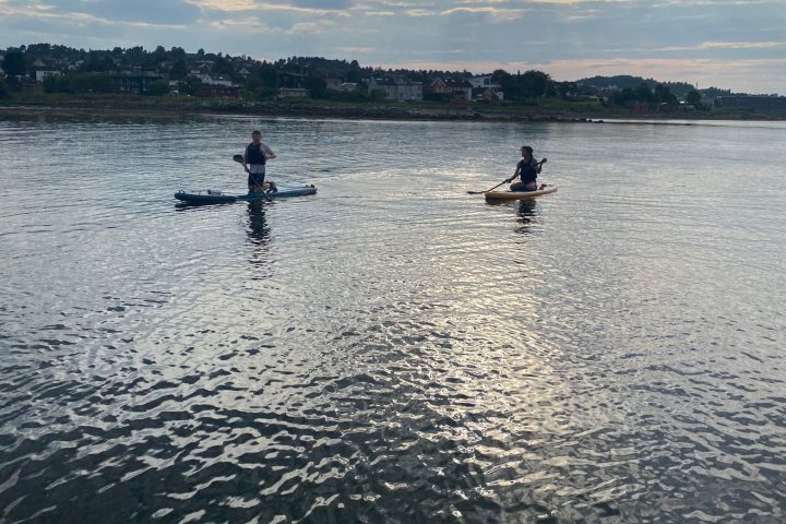 a group of people standing next to a body of water