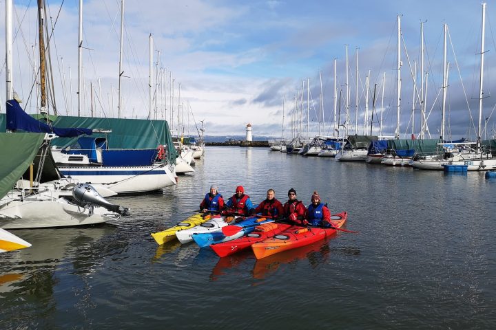 a group of people in a small boat in a body of water