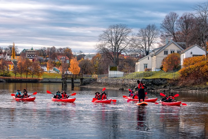 a group of people rowing a boat in the water