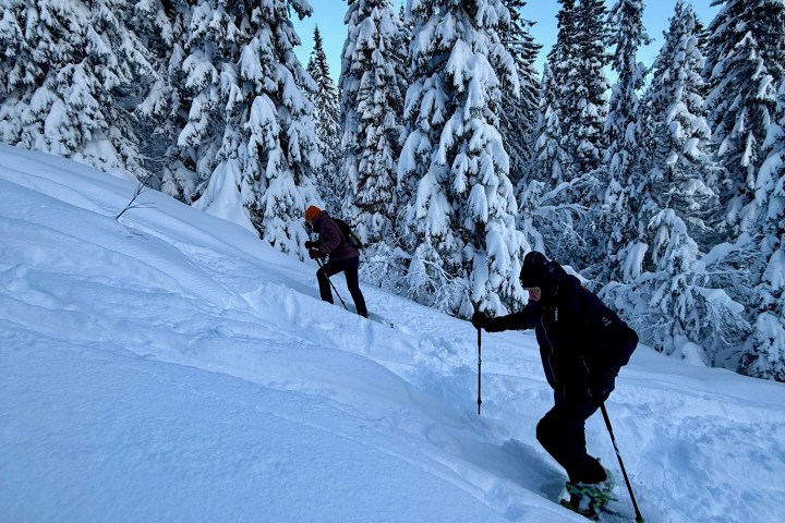 a man riding skis down the side of a snow covered slope