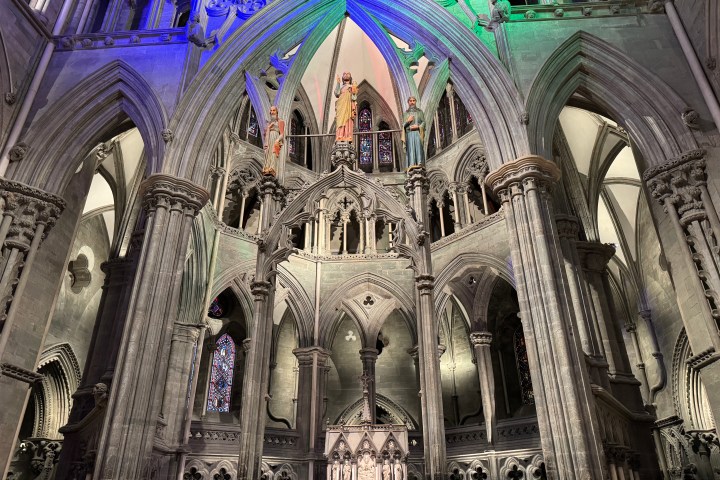 Gothic cathedral interior with ornate arches and statues.